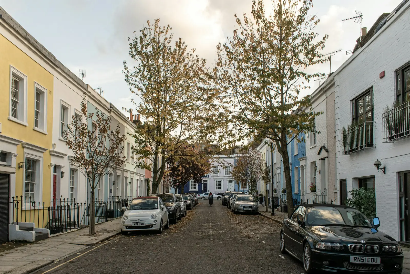 Quiet London street lined with cream, yellow and white painted houses