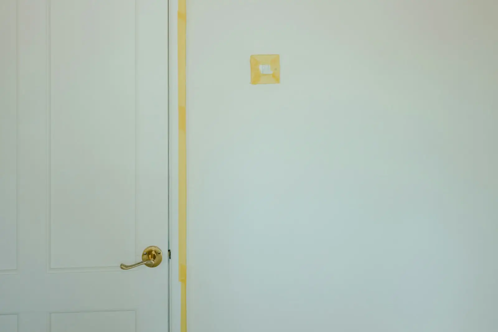 Decorator's masking tape along a door frame in a room ready for painting