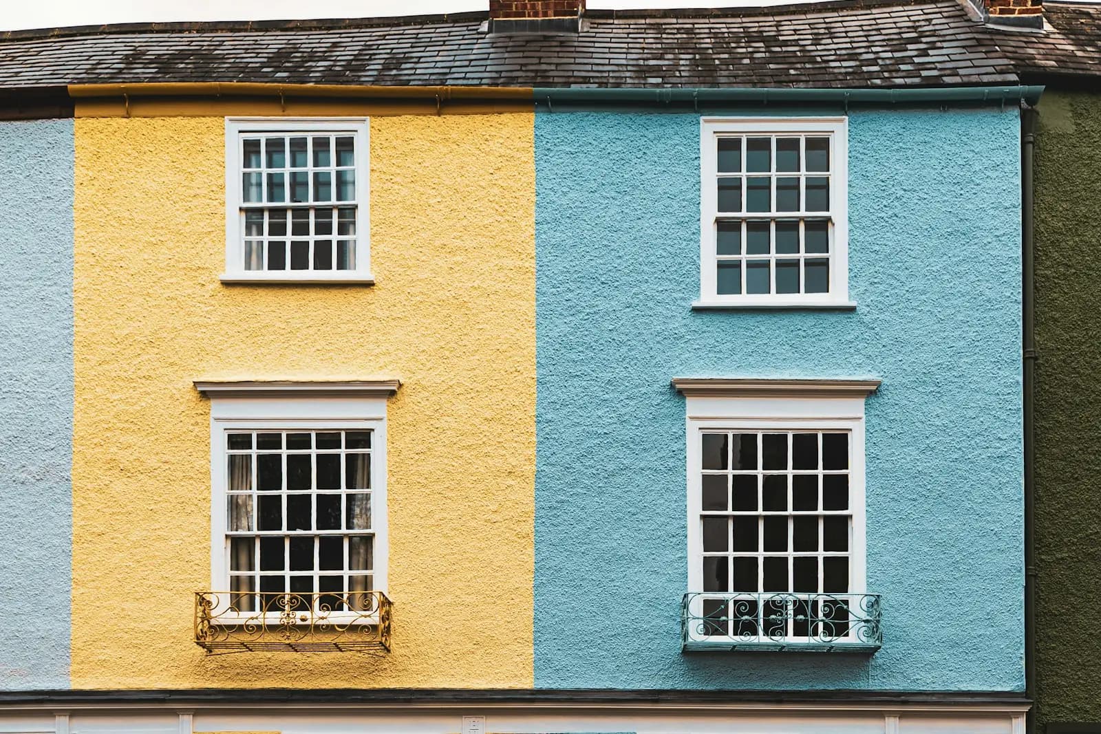 Yellow and blue painted townhouses with white sash windows