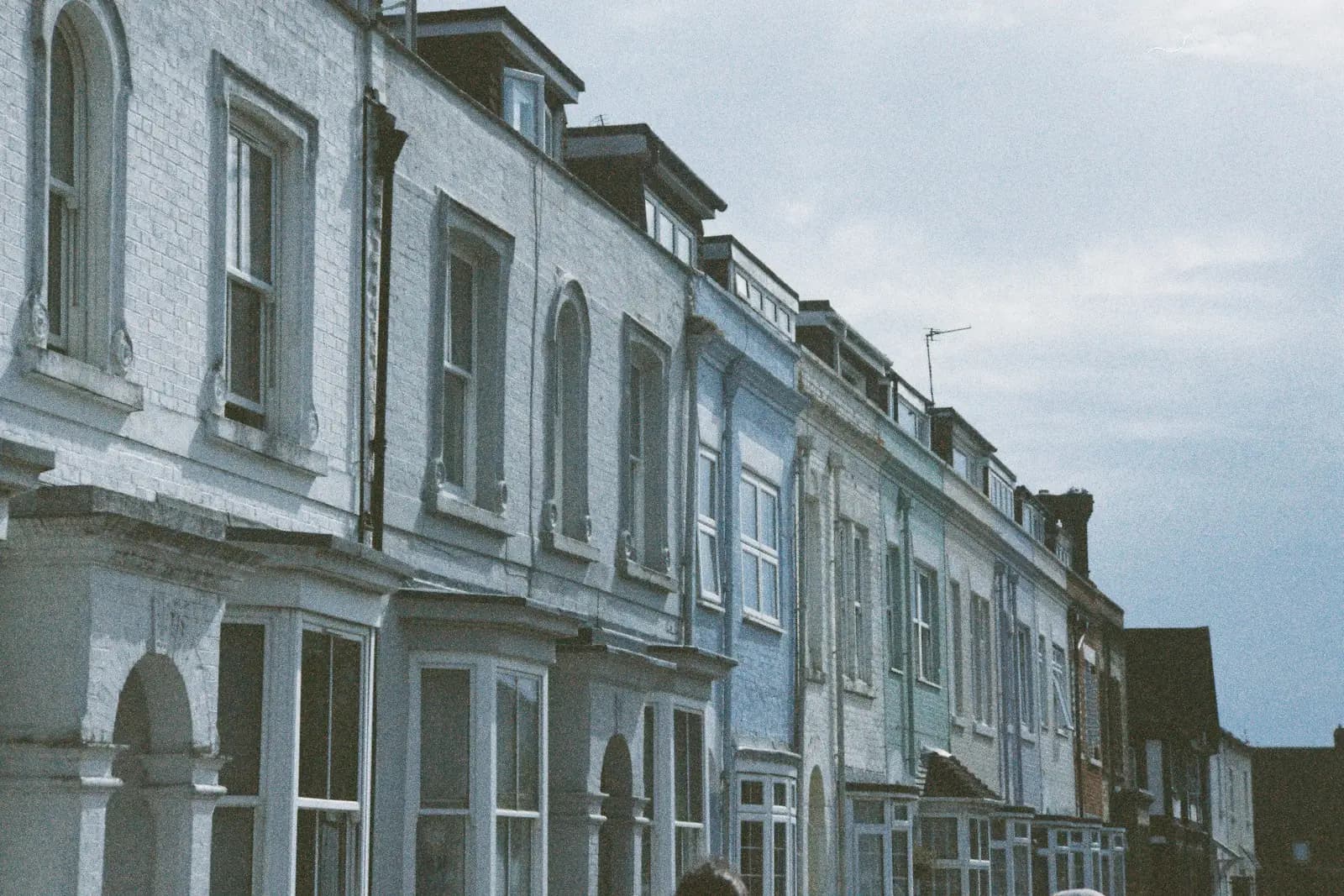 Terrace of white and pale blue painted houses with bay windows
