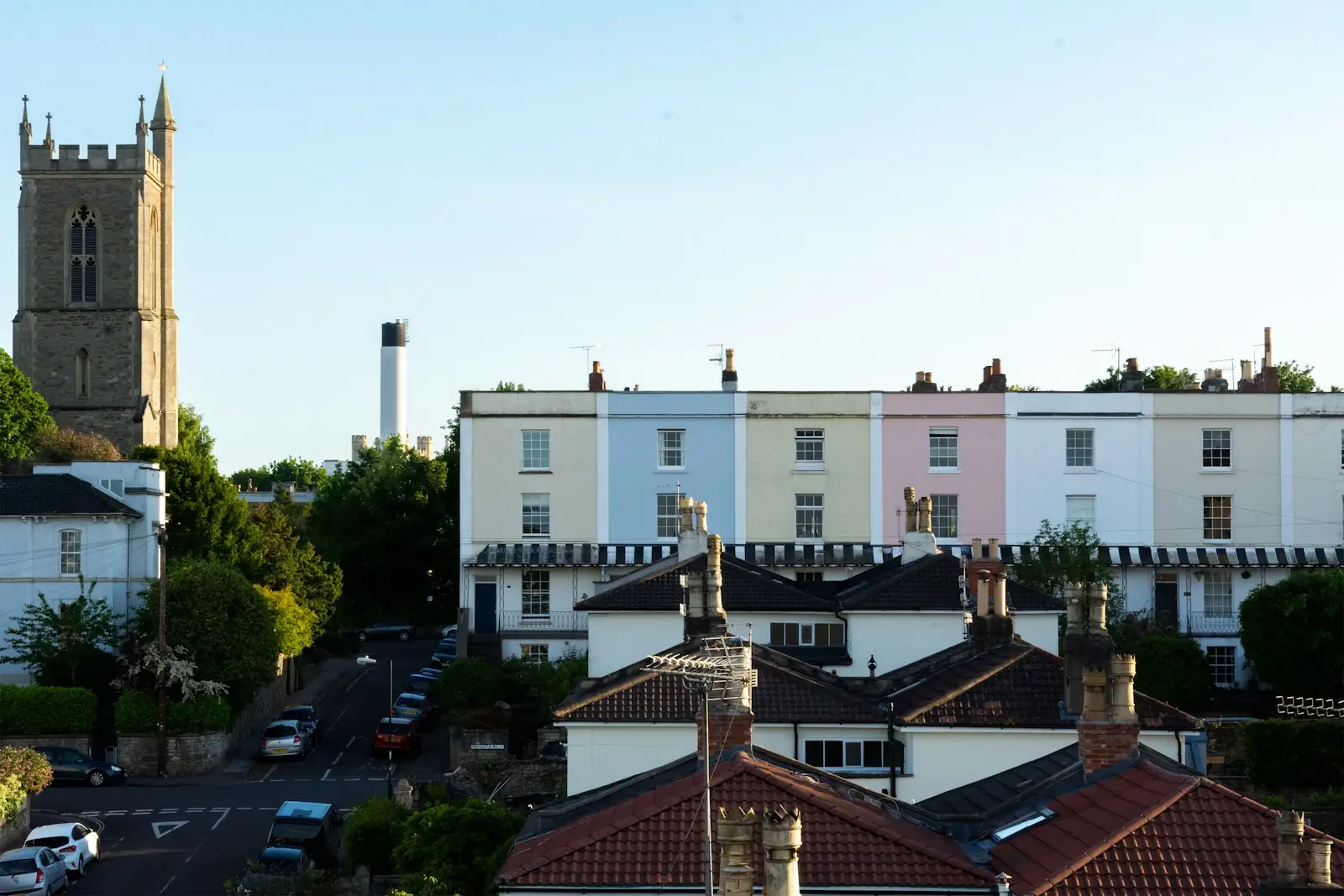 Pastel painted terrace of houses beside a church tower