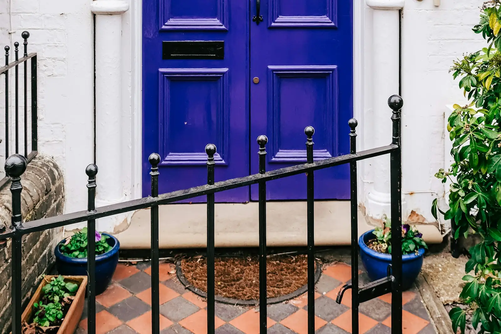 Purple gloss front door with white painted pillars and railings