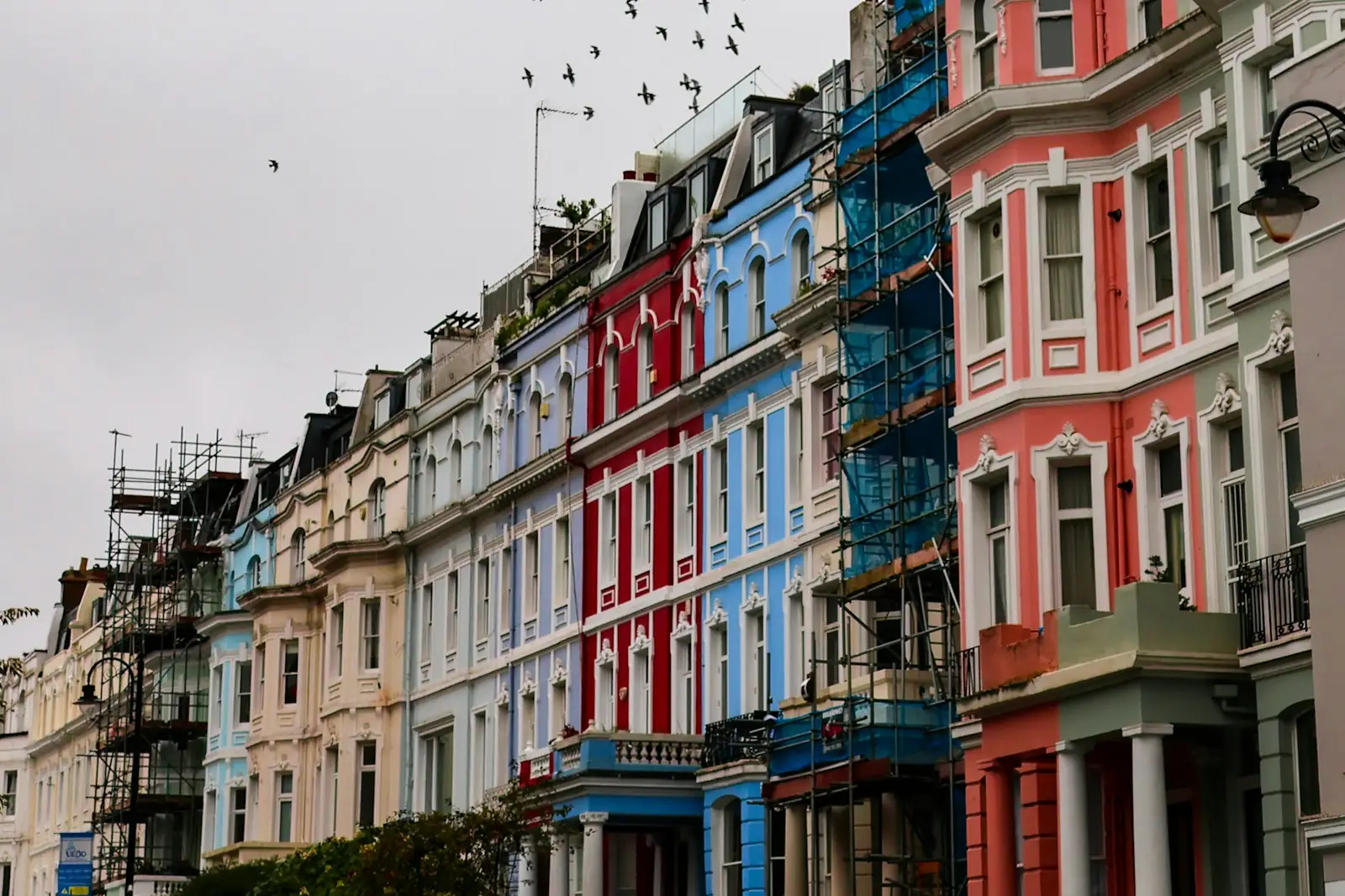 Scaffolding on a row of painted terraced houses during exterior redecoration