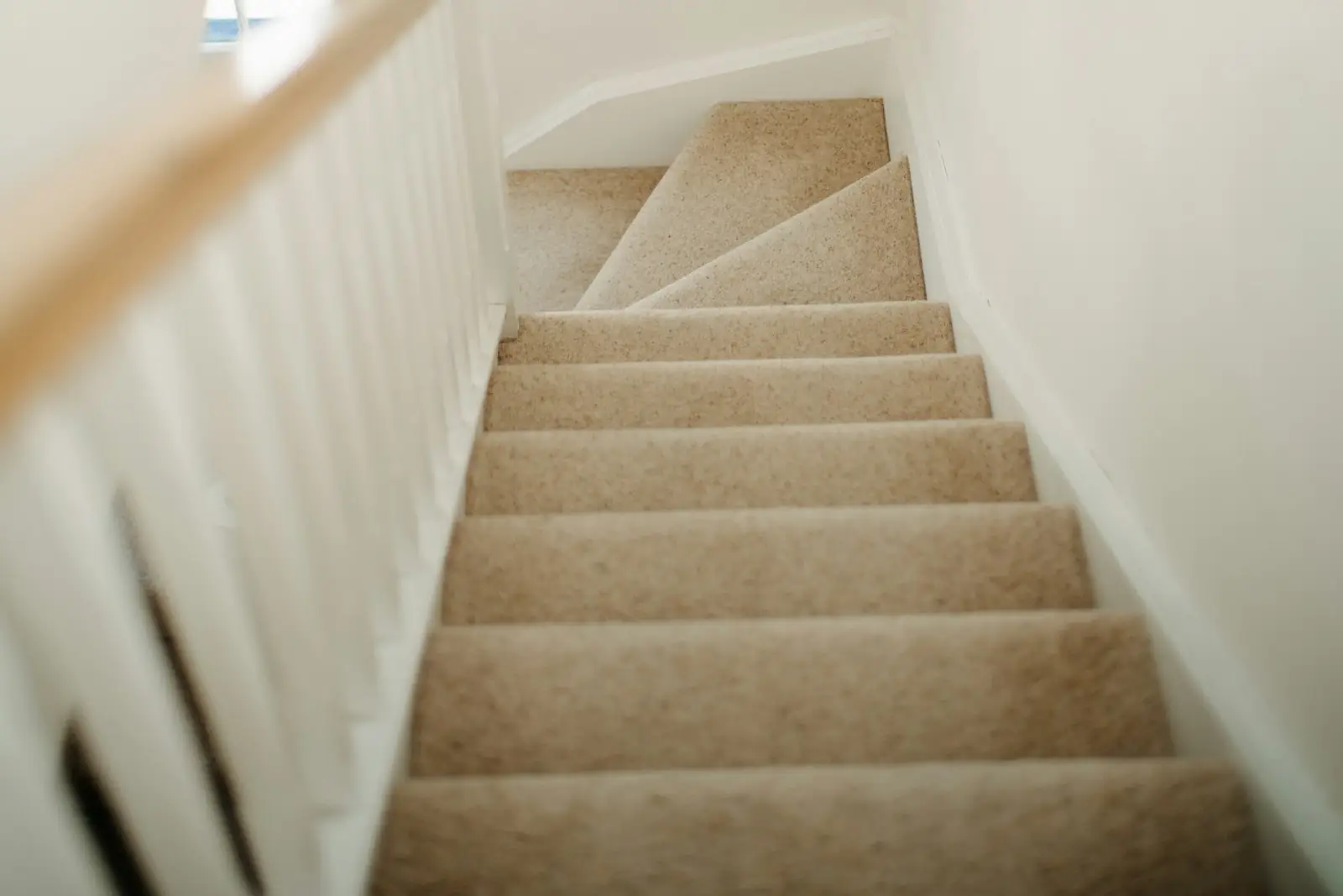 Painted stairwell and landing with a white handrail